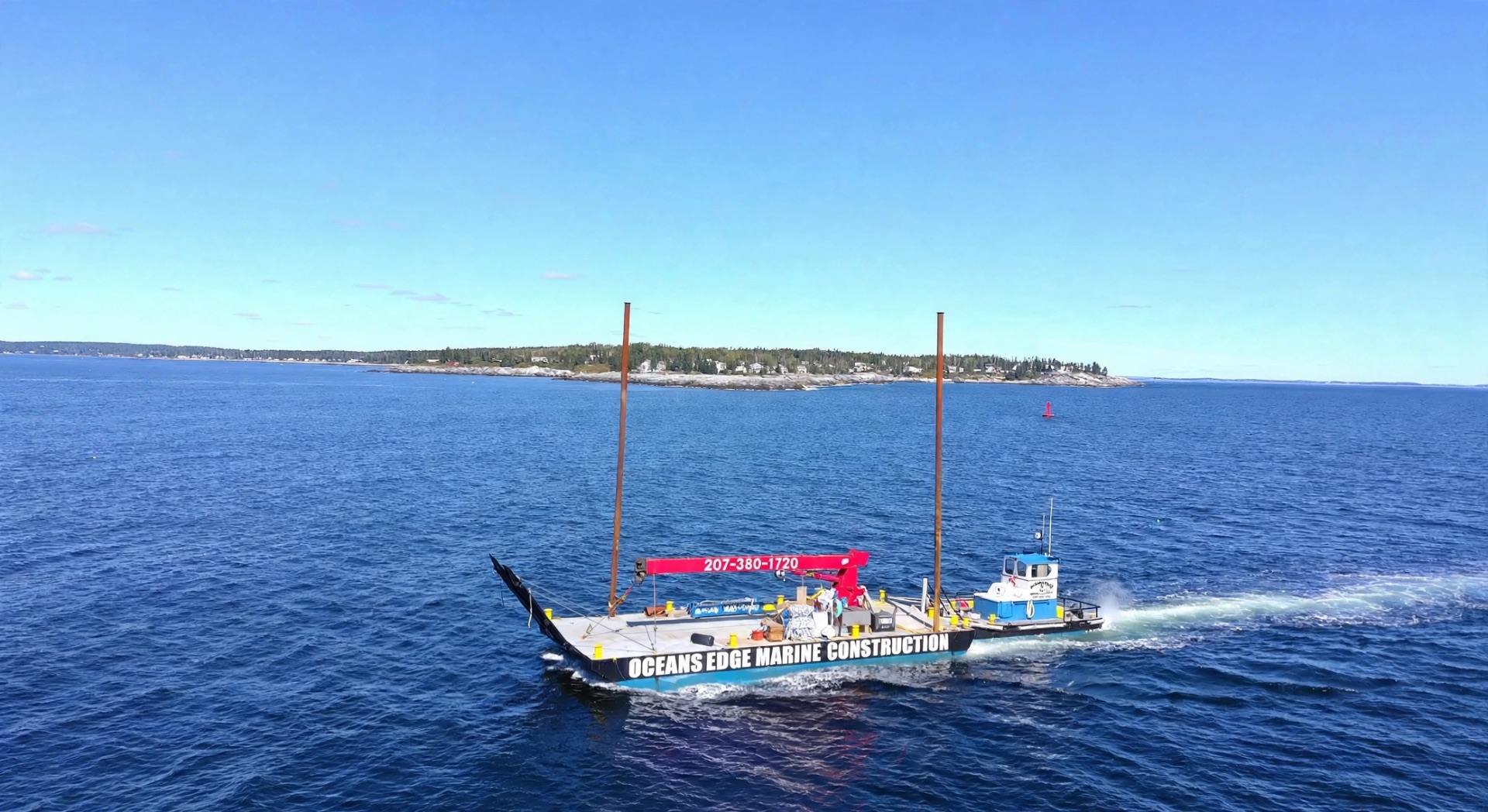 Ocean's Edge Marine construction barge with crane working along the Midcoast Maine shoreline